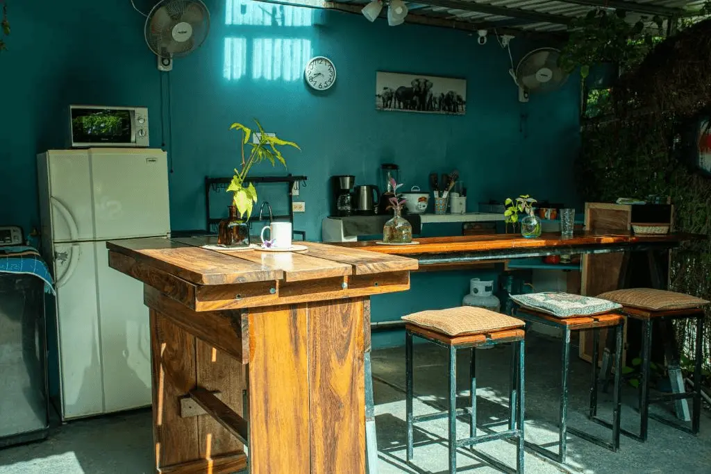 Community outdoor kitchen with rustic wooden island and bar, relaxed atmosphere for socializing in Tamarindo.